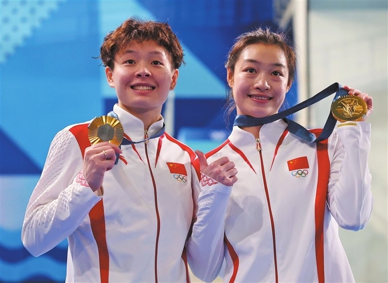 Chinese divers Chen Yiwen (L) and Chang Yani show their gold medals. Xinhua